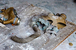 Gas masks on wooden table at school in dead abandoned ghost town of Pripyat in Chernobyl alienation zone, Ukraine