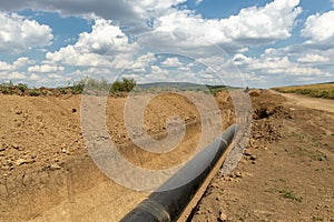 Gas and oil pipeline construction. Pipes welded together. Big pipeline is under construction. Cloudy sky