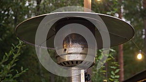 Gas outdoor heater working on terrace. Steel metal warmer.