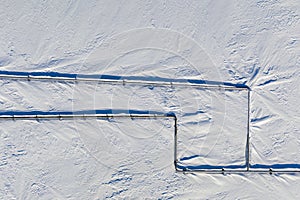 Gas pipelines, crane and pipes for gas and oil transportation, top view of an oil and gas pipe in white snow