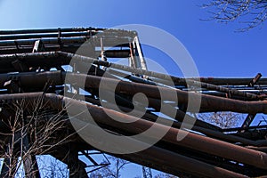 Gas pipelines at a metallurgical plant against the blue sky. Concept of economic crisis. Ecology concept