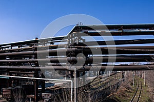 Gas pipelines at a metallurgical plant against the blue sky. Concept of economic crisis. Ecology concept