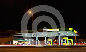 Gas station with motion traffic in city at night. Long exposure of car light, Czech republic