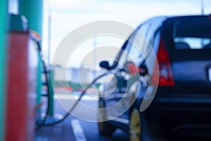 Gas station at night. The car is fueled with gasoline. Blurred photo for background