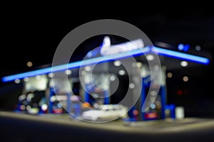 Gas station at night. The car is fueled with gasoline. Blurred photo for background