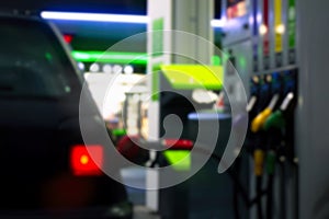 Gas station at night. The car is fueled with gasoline. Blurred photo for background
