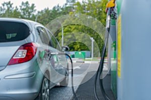 Gas station at night. The car is fueled with gasoline. Blurred photo for background