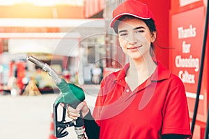 Gas station service staff worker women happy smiling with fuel nozzle for car gasoline refill job