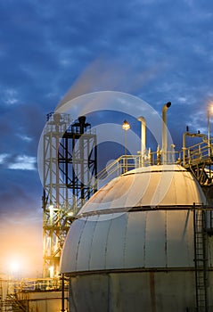 Gas storage spheres tank in refinery plant at twilight column to