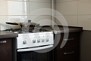 Gas stove and dirty frying pan in the kitchen in an apartment in Ukraine, kitchen furniture and appliances, kitchen