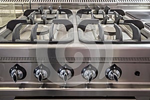 Gas stove, a professional one made of steel aluminium, on display, brand new, with unused burners.