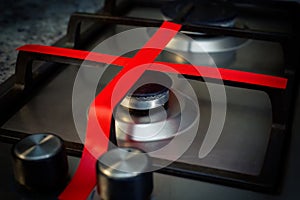 Gas stove with red ribbon criss-cross, does not work at home, in the kitchen. Unavailability of natural gas.