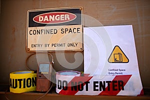 Gas test leak atmosphere confined space warning sign permit entry by permit only and red barricade danger tape