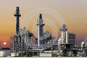 Gas turbine electric power plant industry in Asian industrial estate isolated on sky of sunset and cargo ship background.