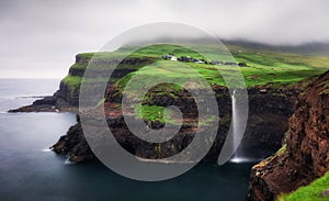 Gasadalur village and Beautiful waterfall with dark clouds, Vagar, Faroe Islands, Denmark photo