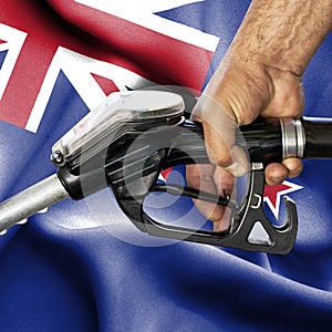 Gasoline consumption concept - Hand holding hose against flag of New Zealand