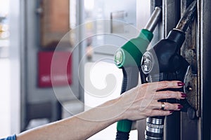 Gasoline and diesel distributor at the gas station. The woman is going to refuel the car.