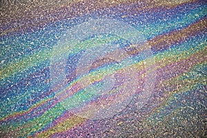 Gasoline flows on the asphalt surface. Iridescent stains of gasoline.