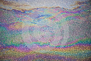 Gasoline flows on the asphalt surface. Iridescent stains of gasoline.