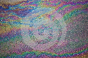 Gasoline flows on the asphalt surface. Iridescent stains of gasoline.