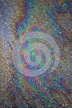 Gasoline flows on the asphalt surface. Iridescent stains of gasoline.