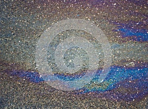 Gasoline flows on the asphalt surface. Iridescent stains of gasoline.