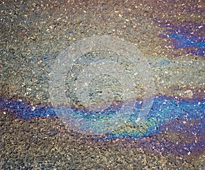 Gasoline flows on the asphalt surface. Iridescent stains of gasoline.