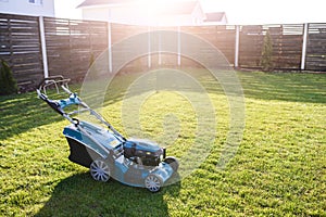 Gasoline lawn mower on the green grass