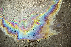 Gasoline stain on the asphalt. Fuel texture. Rainbow spot of combustible liquid