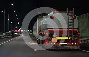 Gasoline tanker moves along the road at night.