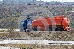 Gasoline tanker moves on a country road. Side view