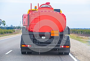 gasoline tanker is moving on a single-lane country road.