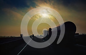 Gasoline tanker rides the highway in the evening sun rays