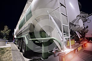 Gasoline transporter truck with lights on at night