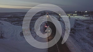 Gasoline truck moving along roadside on winter highway drone view