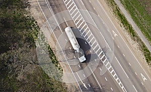 Gasoline truck Oil trailer on highway driving along the road. Tank vehicle at work aerial view above