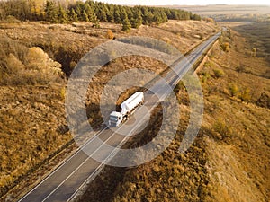 Gasoline truck Oil trailer, truck on highway driving along the road. Tank truck at work aerial view above