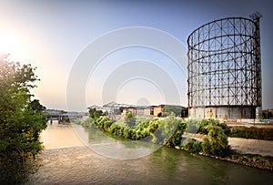 Gasometer and Tiber river at the ancient River Port in the Ostiense district. Rome, Italy