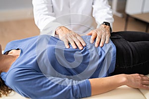 Gastroenterologist Doctor Consulting Woman In Clinic