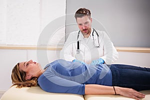 Gastroenterologist Doctor Consulting Woman In Clinic