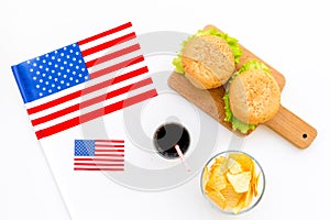 Gastronomical tourism with american flag and burgers, chips, coke on white background top view