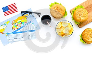 Gastronomical tourism with american flag, passport, tickets, map, burgers, chips, coke on white background top view