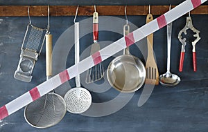 Gastronomy corona lockdown, restaurant kitchen utensils with warning tape,symbolic picture