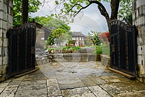 Gate of enclosed old-fashioned buildings in cloudy spring after