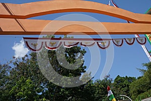 A gate at the entrance of a village has a red and white flag umbul umbul attached which is the Indonesian flag