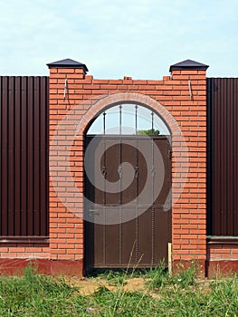 Gate in fence with brick pillars