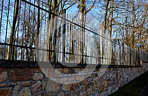 Gate and fence at the castle in the autumn sun. the lattice ending the end of the wall protected thieves from improper intruders.
