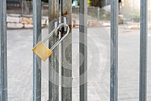 Gate Locked For Safety. Golden Padlock On Metal Gate.