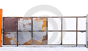 Gate is made of old rusted galvanized metal sheet with old locked padlock. Rusty surface caused by oxidation iron with orange and