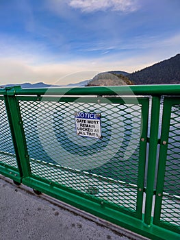 `Gate Must Be Locked` sign on a gate metal fence on the Anacortes to Friday